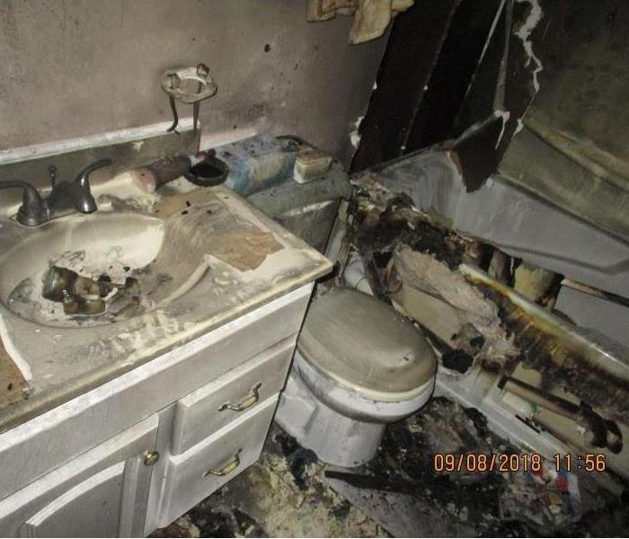 Stark County bathroom with severe fire damage on walls, vanity and tub enclosure